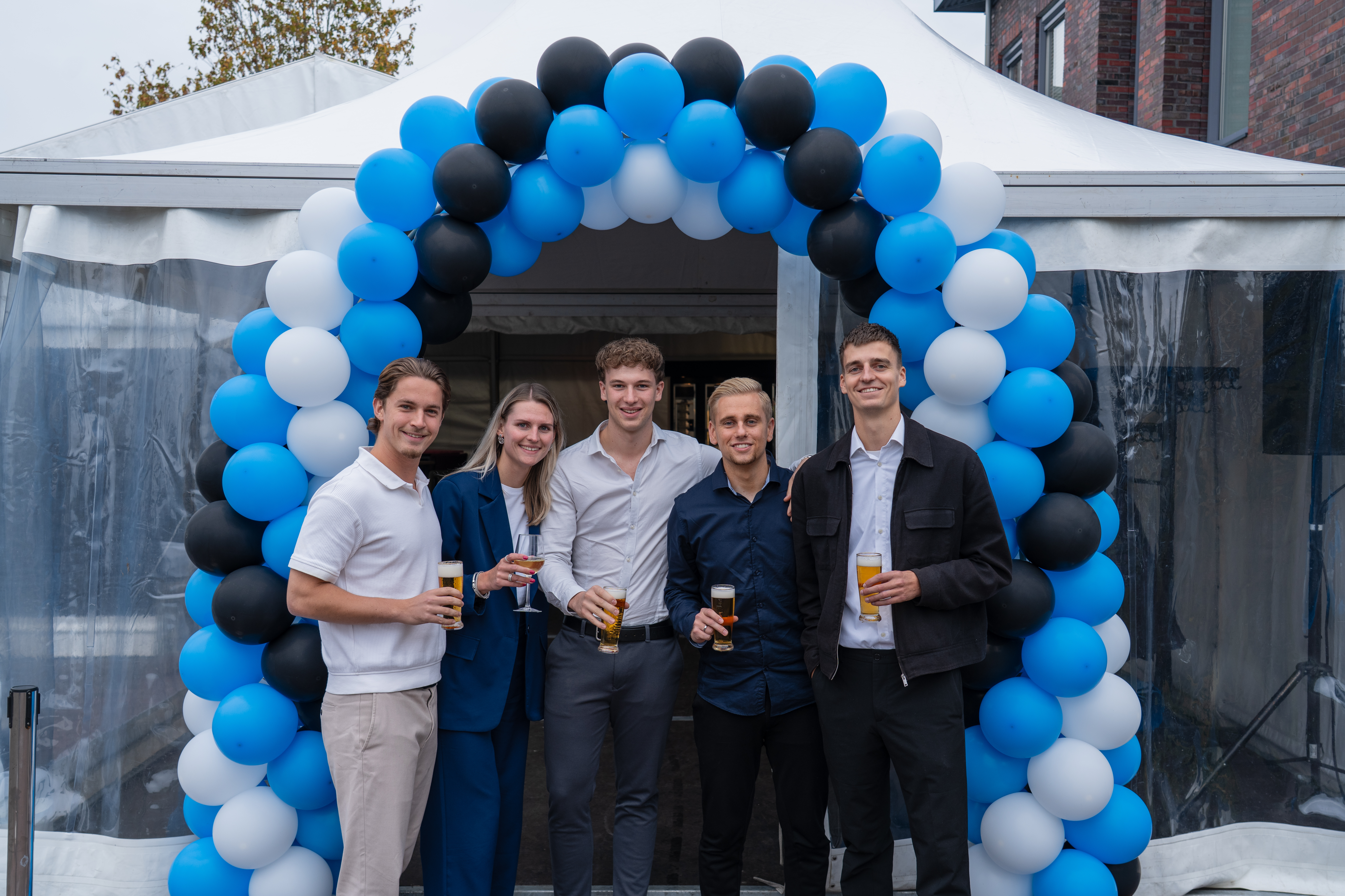 Collega's onder een ballonboog