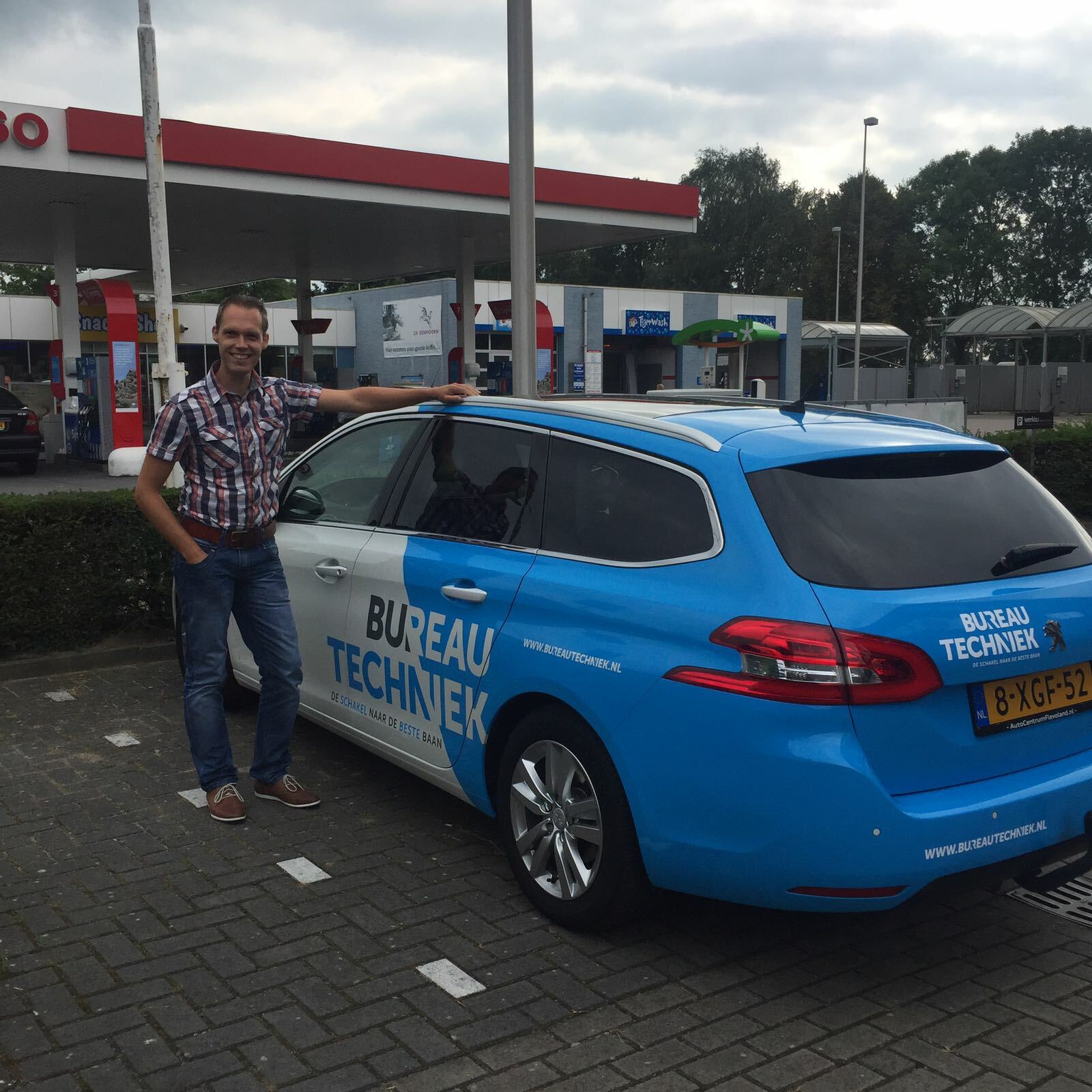 Collega naast een bedrijfsauto van Bureau Techniek